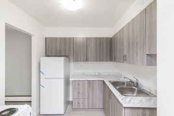 Hamilton apartment for rent - A kitchen with a white fridge and a marble counter top.
