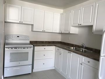Hamilton apartment for rent - A kitchen with white cabinets and a stainless steel oven.