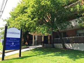 Stoney Creek apartment for rent - A sign for Commodore Apartment Homes stands in front of a building.