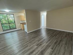 Stoney Creek apartment for rent - A room with wooden flooring and a window overlooking a tree-filled yard.