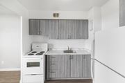 Hamilton apartment for rent - A white stove and sink in a kitchen with grey cabinets.