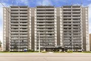 Hamilton apartment for rent - A large, modern apartment building with multiple balconies and a flat roof.