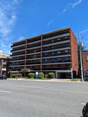 Hamilton apartment for rent - A large red brick building with a parking lot in front.