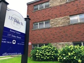 Hamilton apartment for rent - A sign for 137 Duke St. rental suites stands in front of a brick building.