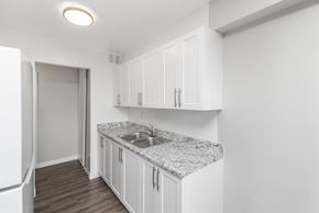 Dundas apartment for rent - A kitchen with white cabinets and a granite countertop.