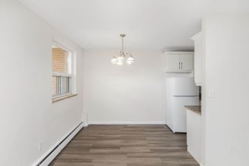 Hamilton apartment for rent - A kitchen with a white refrigerator and wooden flooring.