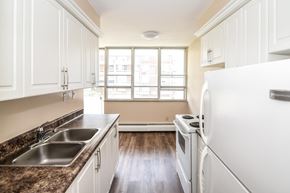 Stoney Creek apartment for rent - A kitchen with white cabinets and a granite countertop.