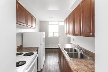 Stoney Creek apartment for rent - A kitchen with a white stove top oven and a white refrigerator.