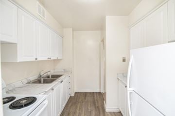 Hamilton apartment for rent - A kitchen with white cabinets and a stove top oven.