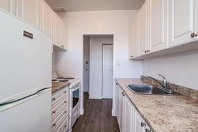 Hamilton apartment for rent - A kitchen with white cabinets and a granite countertop.