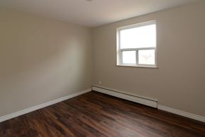 Hamilton apartment for rent - A room with a window and wooden floors.