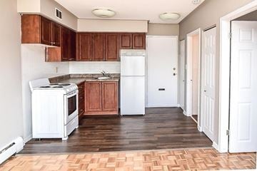 Hamilton apartment for rent - A kitchen with wooden cabinets and a white refrigerator.