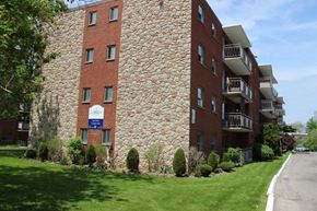 Stoney Creek apartment for rent - A large red brick building with a balcony on the second floor.