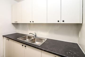 Kitchener apartment for rent - A kitchen with a sink and cabinets.