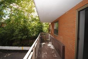 Hamilton apartment for rent - A balcony with a white railing and a brick wall.