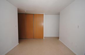 Hamilton apartment for rent - A room with a white wall and a brown wardrobe.