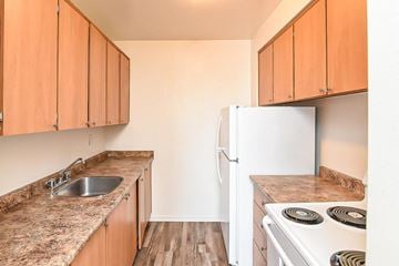 Hamilton apartment for rent - A kitchen with wooden cabinets and a white refrigerator.