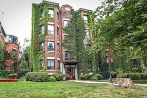 Hamilton apartment for rent - A building with a red door is covered in green vines.