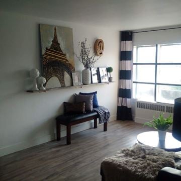 Kitchener apartment for rent - A living room with a wooden bench and a painting of the Eiffel Tower on the wall.