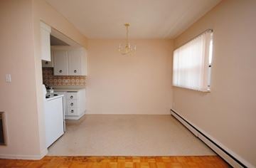 Hamilton apartment for rent - A kitchen with a white refrigerator and a chandelier hanging from the ceiling.