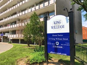 Hamilton apartment for rent - A sign for King William Rental Suites stands in front of a building.