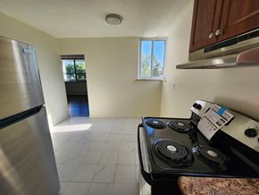 Kitchener apartment for rent - A kitchen with a stove, refrigerator, and a window.