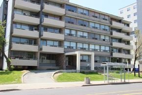 Hamilton apartment for rent - A large concrete building with many windows and balconies.
