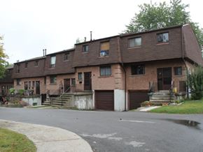 Hamilton apartment for rent - A brown building with a grey road in front.