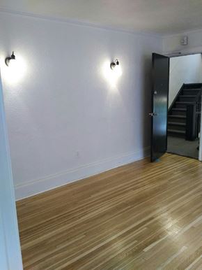 Kitchener apartment for rent - A room with wooden floors and two wall lights.