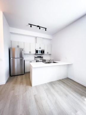 Kitchener apartment for rent - A kitchen with a refrigerator, microwave, and oven.