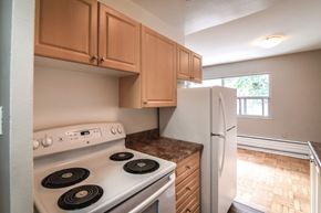 Stoney Creek apartment for rent - A kitchen with a white stove and wooden cabinets.