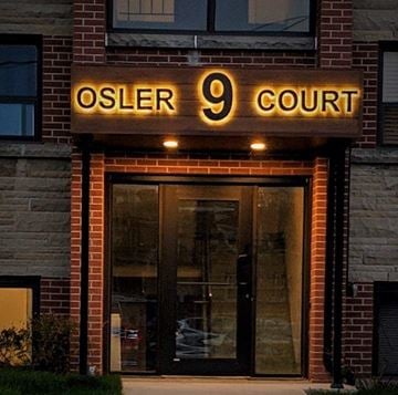 Dundas apartment for rent - The front of a building with a glass door and a sign that says Osler 9 Court.