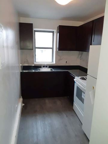 Dundas apartment for rent - A kitchen with a white fridge and black countertops.