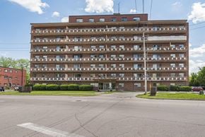 Burlington apartment for rent - A large apartment building with a parking lot in front.