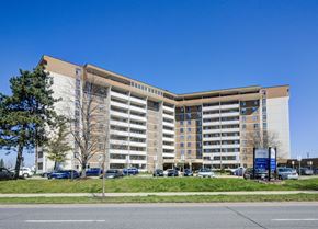 Hamilton apartment for rent - A large, modern building with a parking lot in front.