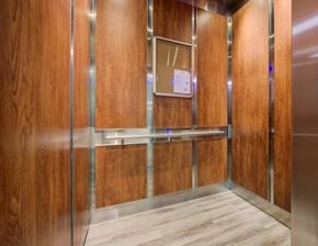 Hamilton apartment for rent - A wooden elevator with a metal frame and a paper on the wall.