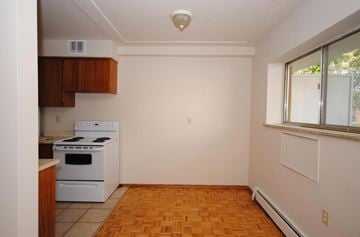 Hamilton apartment for rent - A kitchen with a white stove and wooden cabinets.