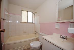 Hamilton apartment for rent - A white toilet sits next to a bathtub in a bathroom.
