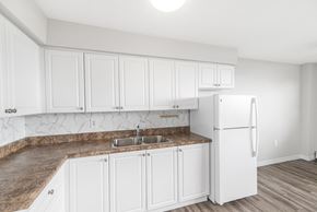 Hamilton apartment for rent - A kitchen with white cabinets and a granite countertop.