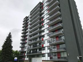 Hamilton apartment for rent - A tall building with balconies and a cloudy sky in the background.