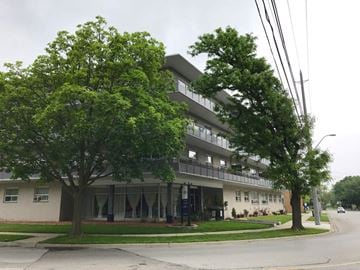 Hamilton apartment for rent - A tree in front of a building with a balcony.