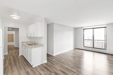 Dundas apartment for rent - A kitchen with white cabinets and a marble countertop.