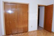 Stoney Creek apartment for rent - A room with a wooden floor and a large wooden wardrobe with two doors and a smaller door.