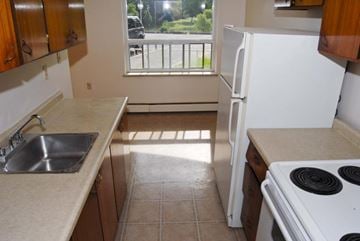 Stoney Creek apartment for rent - A kitchen with a white refrigerator and a stove top oven.