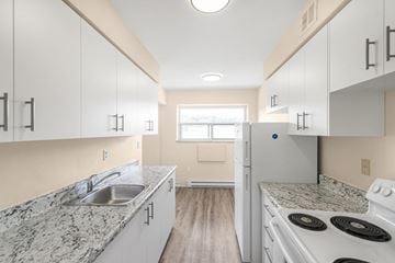 Stoney Creek apartment for rent - A kitchen with white cabinets and a granite countertop.