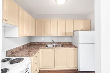 Hamilton apartment for rent - A kitchen with a white refrigerator and a white stove with a marble counter top.