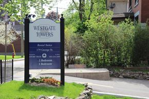 Hamilton apartment for rent - A sign for Westgate Towers rental suites stands in front of a building.