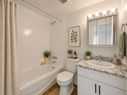 Hamilton apartment for rent - A white bathroom with a toilet, sink, and a shower.