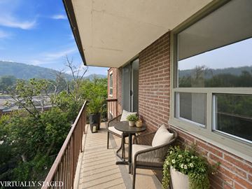 Hamilton apartment for rent - A balcony with a table and chairs overlooking a body of water.