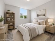 Hamilton apartment for rent - A bedroom with a large bed, a nightstand, and a bookshelf.